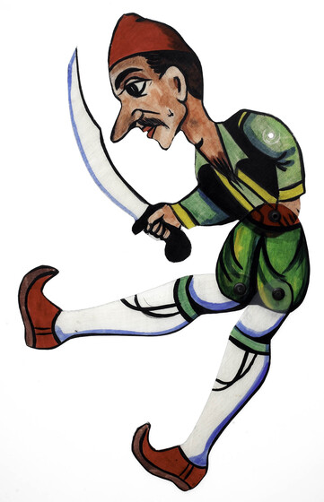 Acrylic figure of a man, jointed with pins at the waist and knees. He carries a scimitar style sword, and wears knee high white socks, red pointed shoes, green shorts and a green shirt with black vest and red cap. He is positioned with legs tilted forwards.