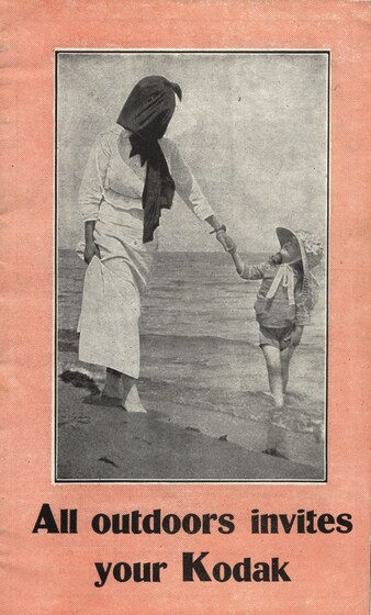 Leaflet with text 'All outdoors invites your kodak' and image of young woman and young girl walking barefoot and holding hands in beach waves. 