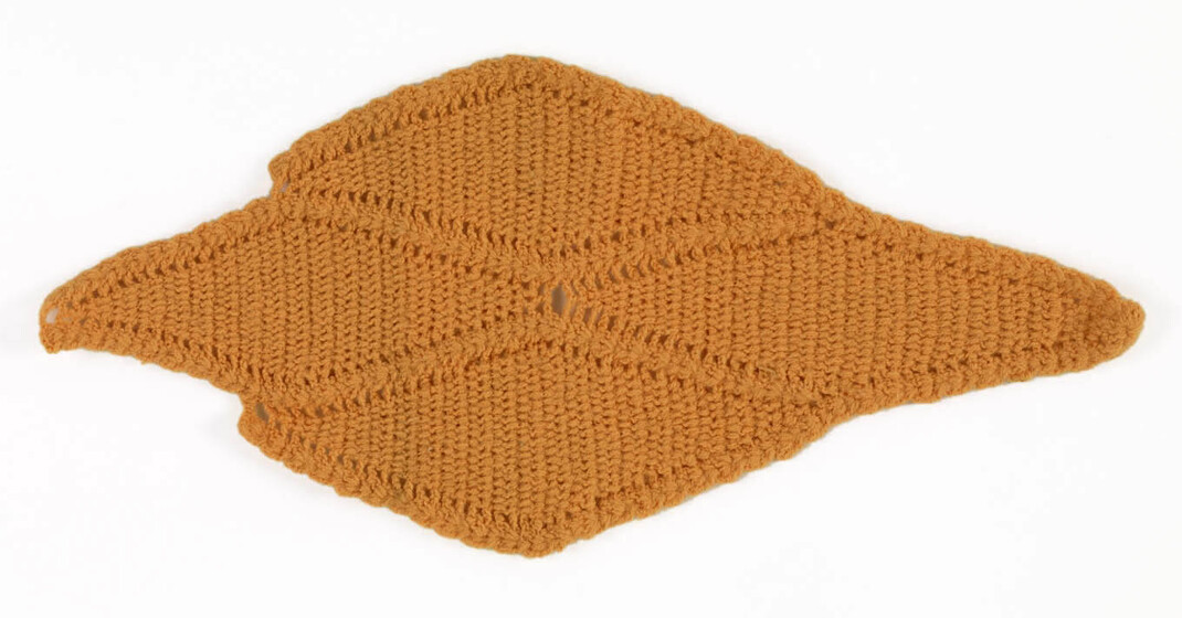 Orange wool crocheted tightly into a diamond shape, made of four smaller diamond panels. 