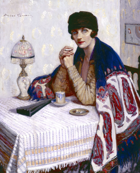 Painting of a woman with a shawl draped over her shoulders, seated at a table. The table has a lamp, fan, cup and saucer, and cigarette tray on it. 