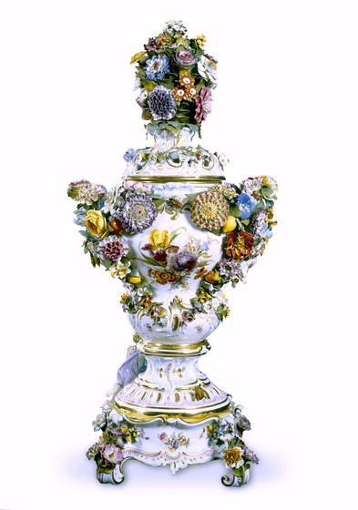 Highly ornate porcelain vase, with raised coloured flowers covering the entire surface.