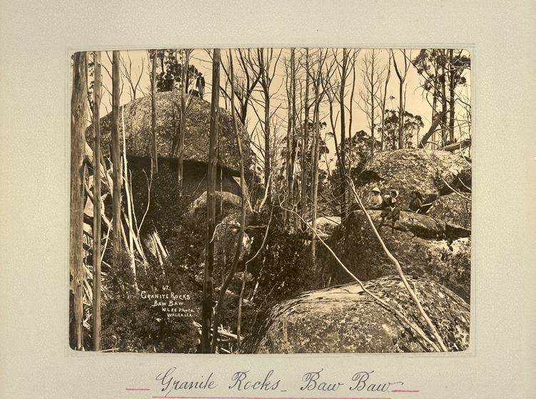 Black and white landscape photograph thin tree trunks in front of a several large rocks and boulders. Text on the surrounding photo mount reads 'Granite Rocks Baw Baw'