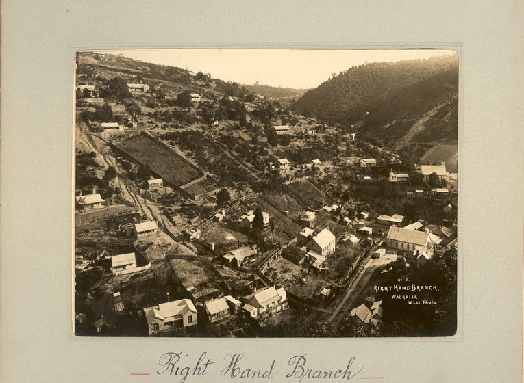 BLack and white aerial photograph of a township, with hills behind. Text on the surrounding mount board reads 'Right Hand Branch'