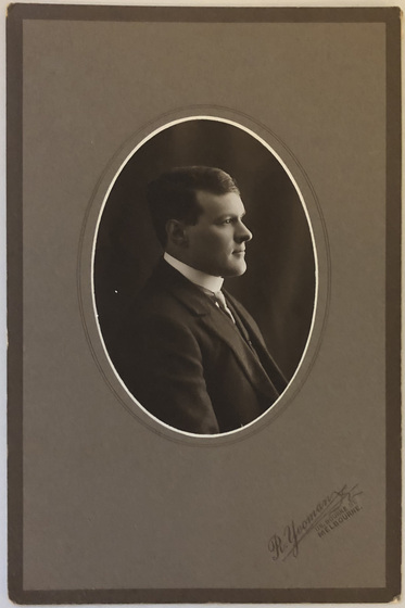 Framed photograph of man in suit in profile, facing right.