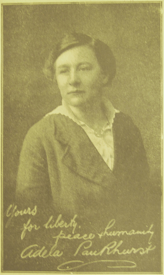 Photograph of woman facing camera with handwritten inscription across the bottom "Yours for liberty peace & humanity Adela Pankhurst"