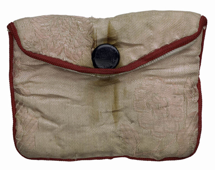 Light pink fabric pouch with button clasp, and red thread edging.