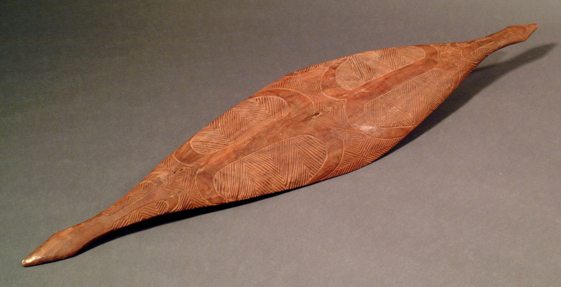 Long and intricately carved timber shield, with narrow ends widening to a wider centre. 