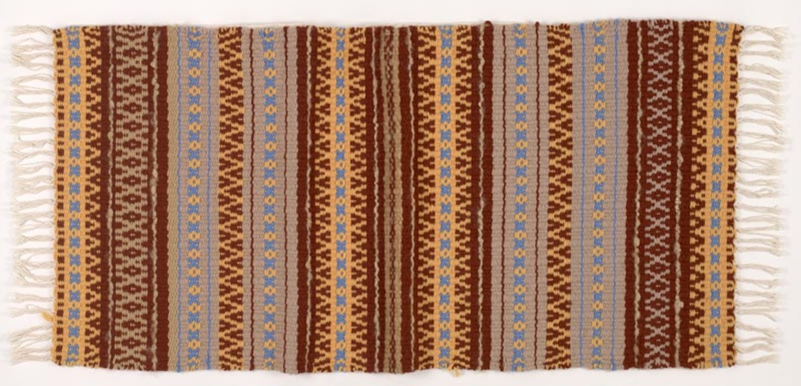 Maroon, yellow and blue lined woven rug with white fringe.