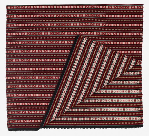 Length of red, white and black striped fabric, with small repeated motifs.