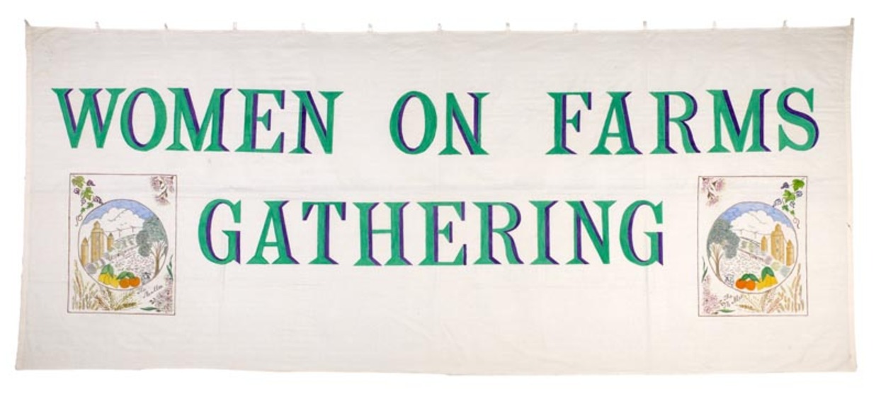 White fabric banner featuring green text with purple shadow reading 'women on farms gathering'. In the bottom left and right corners are two painted farm and produce scenes.
