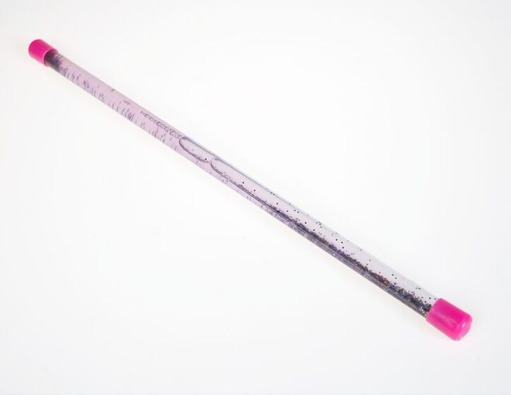 A plastic tube made as a wand with glitter inside and pink caps on either end.