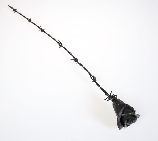 A metal rose with a stem fashioned to look like barbed wire.