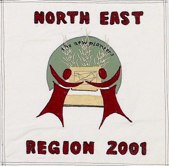 White fabric square with two stylized red figures with arms raised to box of wheat in front of a green circle. Red text above reads 'north east', and below 'region 2001'. 