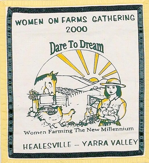 Yellow, green and white fabric square with an image of a woman standing holding produce in front of farmland featuring a horse and chickens and a sun in the background. Text above reads 'women on farms gathering 200 Dare to Dream'. Below reads 'Women Farming the New Millennium Healesville - Yarra Valley'.
