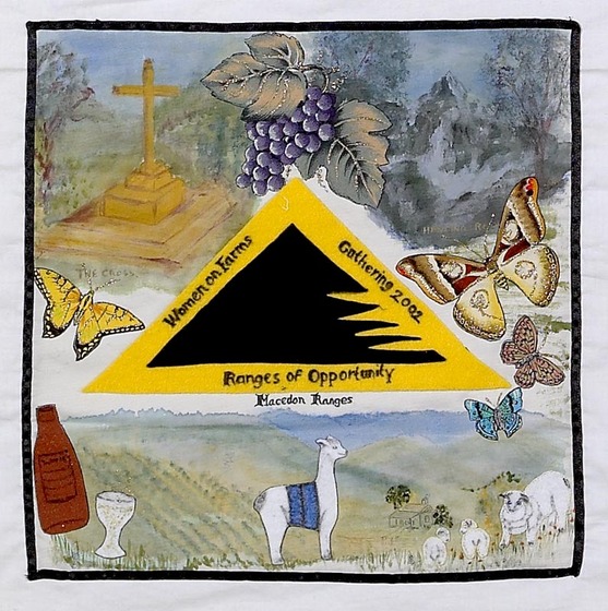 White fabric square with detailed painted images surrounding a yellow and black triable. At the bottom is a llama in a field. Above is a butterfly, cross and grapes. 