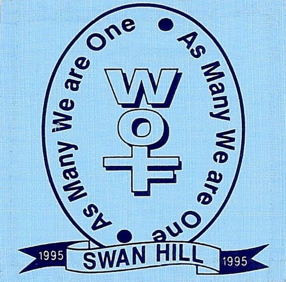 Blue fabric square of an oval with motif of 'WOT' in the centre. Text surrounding the motif reads 'As Many We are One, As Many we are One'. Below on a banner is the text 1995, Swan Hill, 1995'. 