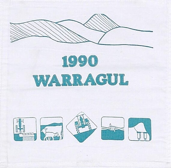White fabric square with the words '1990 Warragul' in green in the centre. Above is a styalised line drawing of a hilly horizon. Below are five small squares featuring different farming images. 
