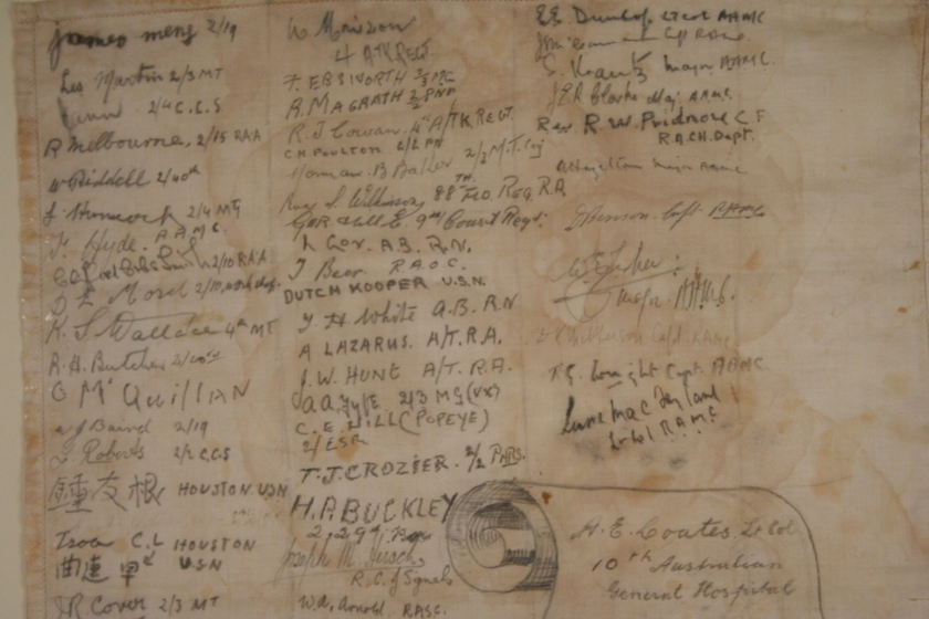 Close up view of paper that is yellow and brown with age, with three columns of handwritten names.