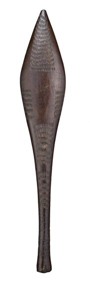 Wooden club with a thin handle made from dark brown timber, and widened area on one end. On the surface are carved dots and dashes in a pattern. 