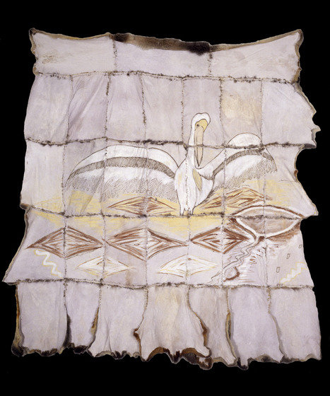 Cloak made with possum skin, stitched together in panels, which all together form a picture of a pelican standing above brown and white diamonds.