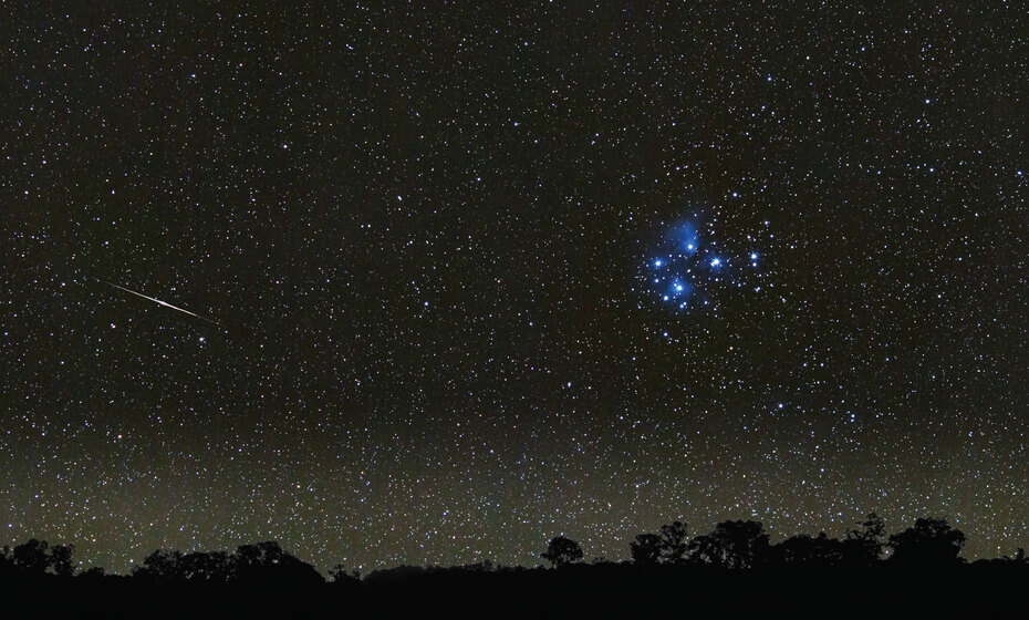 night sky over landscape with bright stars visible