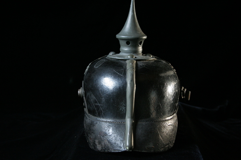 Rear view of black helmet with silver spike on top.