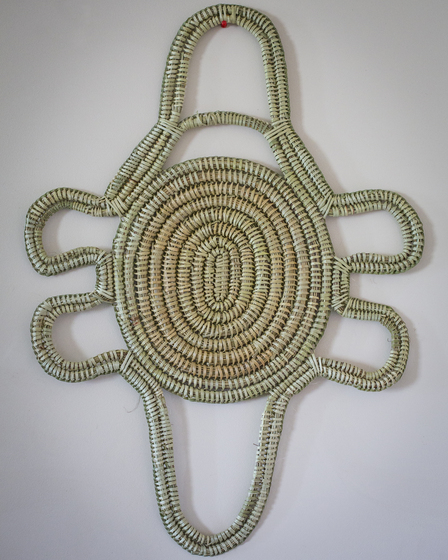 Coiled and women green and brown plant reeds or fibers, created to form  the outline of a platypus shape.