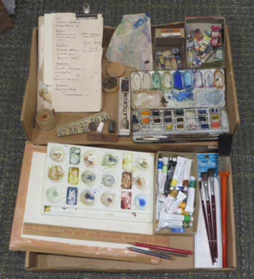 A collection of art supplies in a wooden artist box
