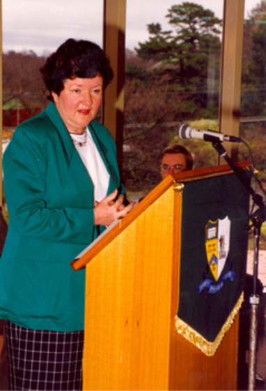 Woman at university lecturn speaking