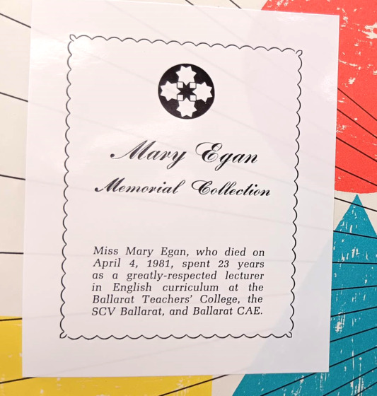 A white bookplate with black text stuck into a colourful children's book